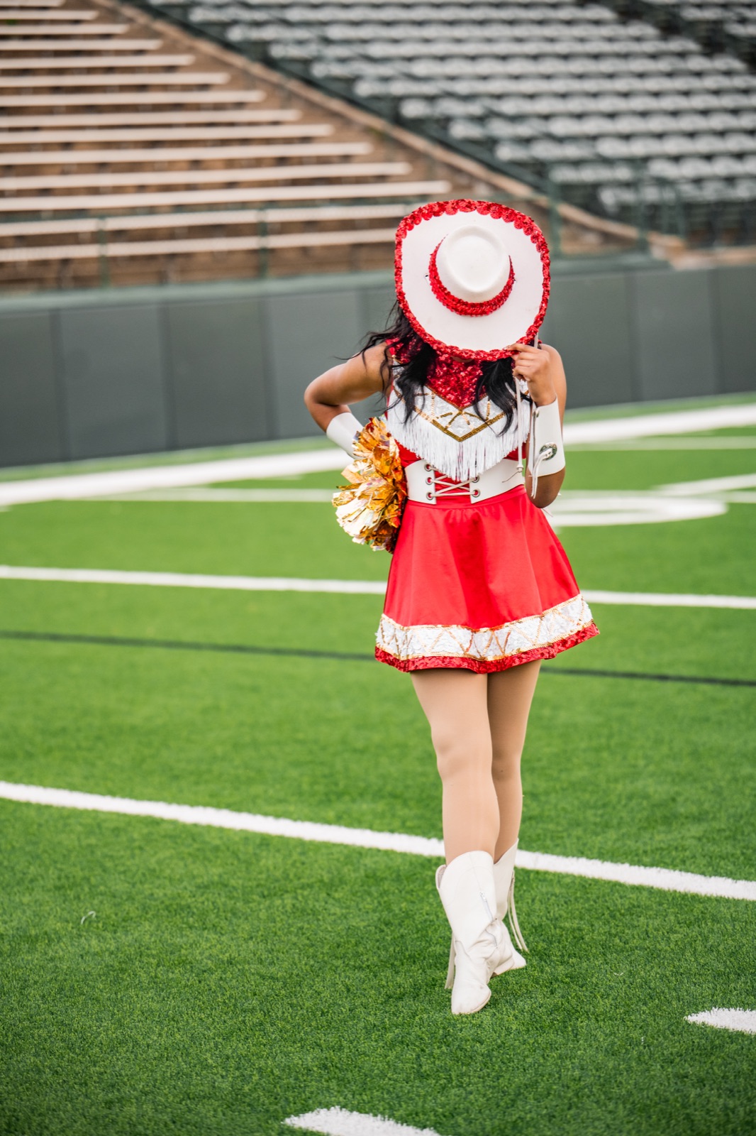 Jewel walking the field, hat tipped forward